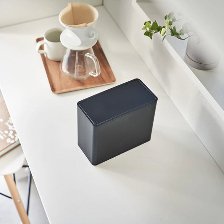 Kaffetilbehør oppbevart i sort boks med lokk og enkel form