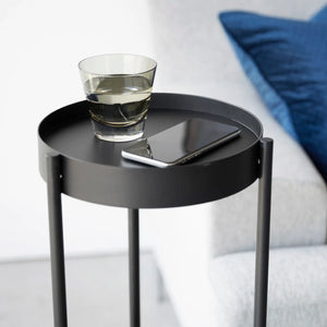 Plantebord i sort metall brukt til planter og dekor i stue