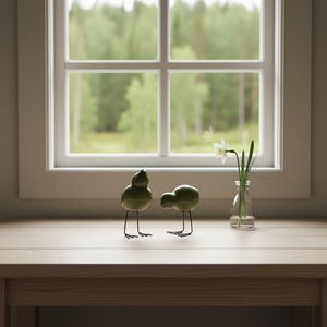 DBKD swedish birds i grønn på trehylle med vårblomster i skandinavisk hyttemiljø.