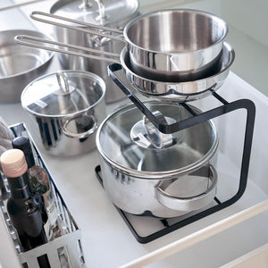 Svart stativ til kjøkkenskap med plass til gryter, lokk og redskaper nærbilde