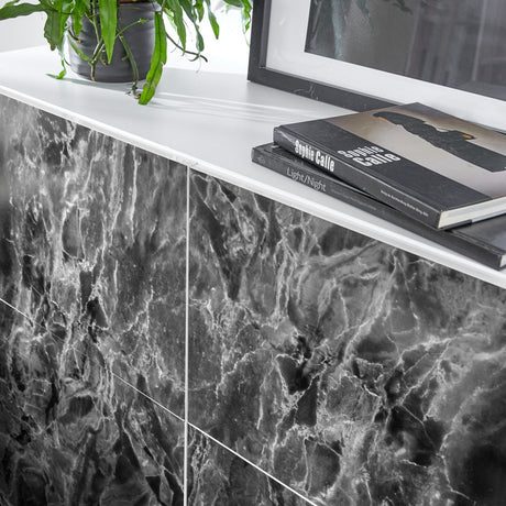 Kontaktplast med mørk marmortekstur og sølvårer på bord
