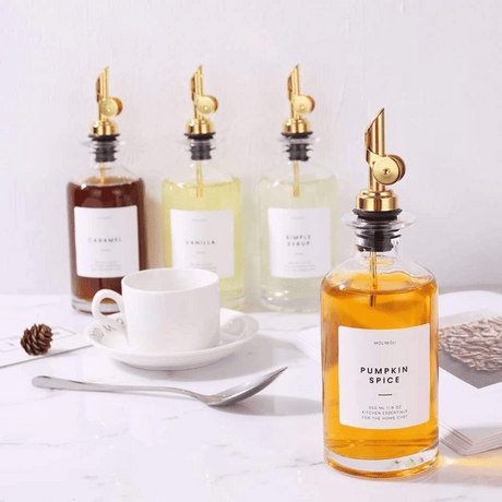 Transparent oljeflaske glass 7 cm diameter med gull metallkorker sett av 2